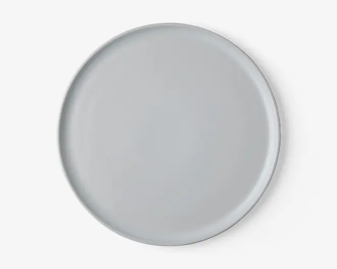 En rund, ensfarvet hvid tallerken med en glat, blank overflade og let hævet kant. Designet er minimalistisk uden mønstre eller dekorationer, velegnet til både hverdagsbrug og formelle middage.