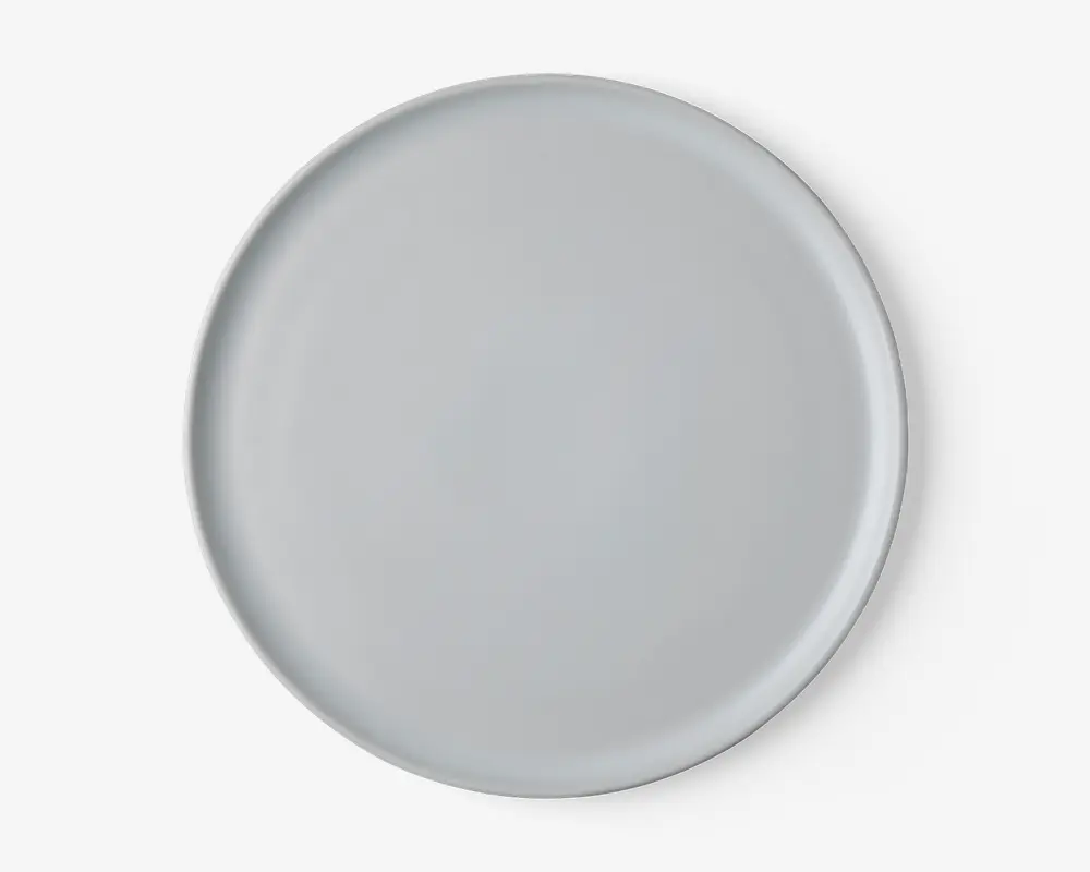 En rund, ensfarvet hvid tallerken med en glat, blank overflade og let hævet kant. Designet er minimalistisk uden mønstre eller dekorationer, velegnet til både hverdagsbrug og formelle middage.