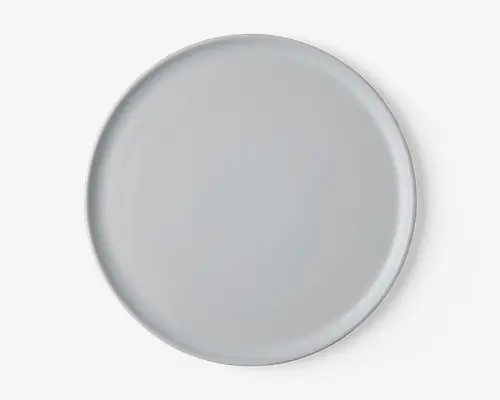 En rund, ensfarvet hvid tallerken med en glat, blank overflade og let hævet kant. Designet er minimalistisk uden mønstre eller dekorationer, velegnet til både hverdagsbrug og formelle middage.