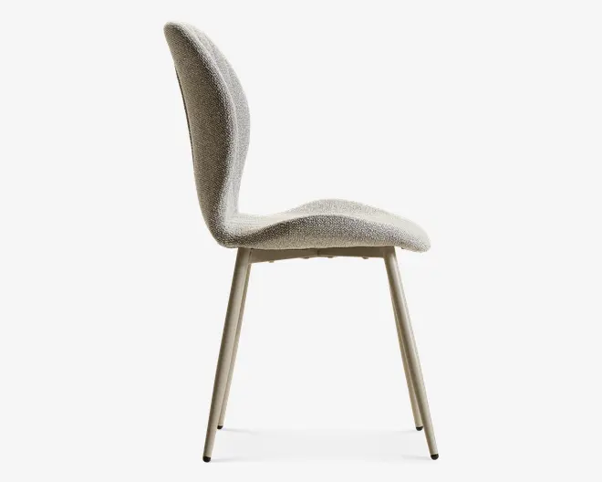 Sidebillede af en beige polstret stol med høj buet ryglæn, blødt sæde og slanke, koniske ben i en matchende lys finish.