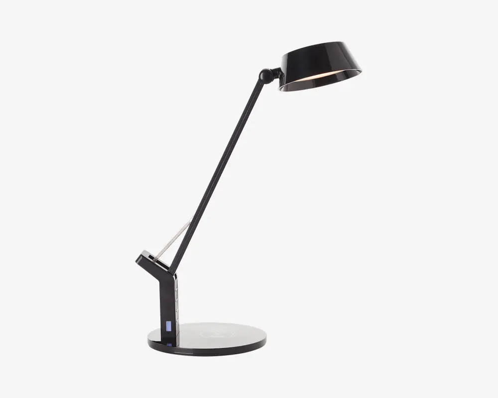 En moderne, sort skrivebordslampe med rund fod og justerbar arm. Lampen har et slankt, kantet design med et drejeled nær foden og et ved lampens hoved, hvilket giver fleksibel indstilling. Lampeskærmen er konisk og har samme blanke sorte finish som resten af lampen. Der ser ud til at være en touch-kontrol eller knap på foden for nem betjening.