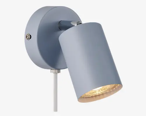 Moderne vægmonteret lampe med en mat grå cylindrisk lampeskærm. Lampen har et justerbart hoved, så lyset kan rettes, en rund bagplade og en synlig tænd/sluk-knap på siden. Designet er minimalistisk og funktionelt, velegnet til accent- eller læsebelysning.