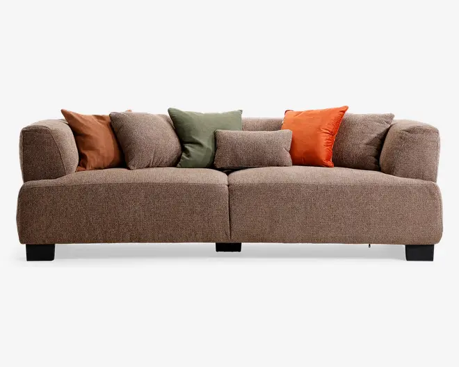 Brun møbelpolstret siddemøbel med lav, firkantet silhuet, brede afrundede armlæn og mørke blokfødder. Leveres med fem pyntepuder i brun, grøn, taupe og orange for et varmt, lagdelt udtryk.