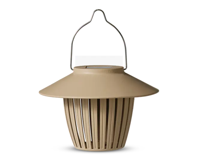 Lysebrun hængende lanterne med bred, skrånende top og lodrette lameller på siderne. Lanternen har et metalhåndtag for nem ophængning og et moderne, minimalistisk design. De åbne lameller på siderne lader lyset skinne igennem og skaber en dekorativ effekt.