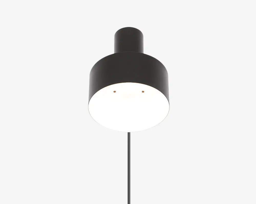 En moderne pendellampe med en mat sort cylindrisk metalskærm. Lampen har et glat, minimalistisk design med rene linjer og en bred, nedadrettet åbning, der udsender et klart og jævnt lys. Toppen af skærmen har en kort, afrundet udvidelse, hvor ledningen er fastgjort, hvilket giver lampen et moderne udtryk.