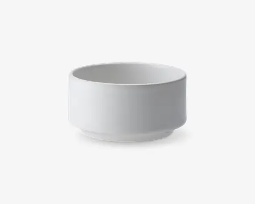 En lille, rund skål med en glat, mat hvid overflade. Skålen har lige sider og en let hævet bund, hvilket giver et moderne og minimalistisk udtryk. Kanten er let buet, og designet er enkelt og funktionelt.
