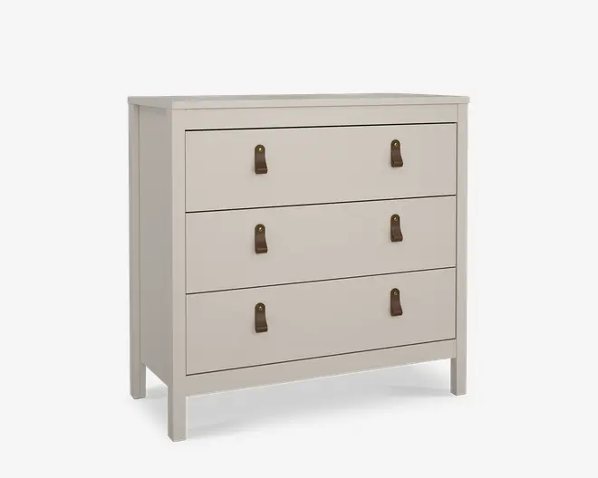 En kommode med tre skuffer i mat, lys beige finish. Hver skuffe har to brune læderstropper som greb, fastgjort med messingfarvede nitter, hvilket giver et moderne og rustikt udtryk. Designet er enkelt og rektangulært med rene linjer og let udstående ben for stabilitet.
