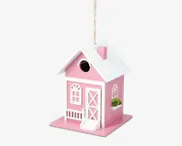 Et lille, dekorativt husformet objekt malet lyserødt med hvide kanter. Det har et saddeltag med skorsten, en lille veranda med gelænder, en hvid dør med krydsmønster og buede vinduer. Der er en cirkulær åbning over døren, og en miniature blomsterkasse med grønne planter er fastgjort under et af sidevinduerne. Objektet hænger i en snor, der er fastgjort til taget.