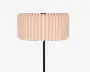 En lampe med en bred cylindrisk plisseret skærm i en lys beige trætonet finish og en slank sort stander.