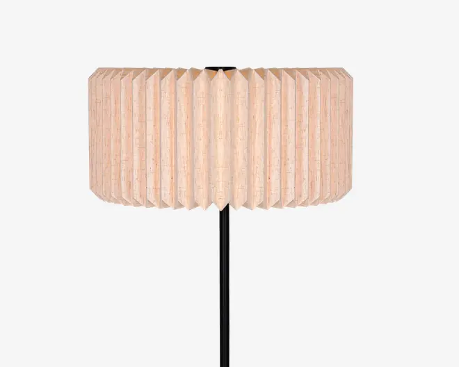 En lampe med en bred cylindrisk plisseret skærm i en lys beige trætonet finish og en slank sort stander.