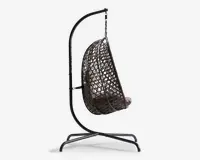 Sidevisning af en hængende æggestol med mørk metalramme og flettet rattan-lignende sæde. Stolen er ophængt i et buet stativ og har en tyk, lysefarvet hynde for ekstra komfort. Sædets åbne gitterdesign giver god luftcirkulation og et moderne udseende.