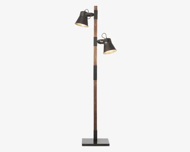 Høj gulvlampe med rektangulær sort fod og en stang i træ. Lampen har to justerbare lampeskærme i sort metal, som sidder i forskellige højder på stangen, så lyset kan rettes i forskellige retninger. Lampeskærmene er let udadbuede og har en metallisk inderside, der giver bedre lysrefleksion.