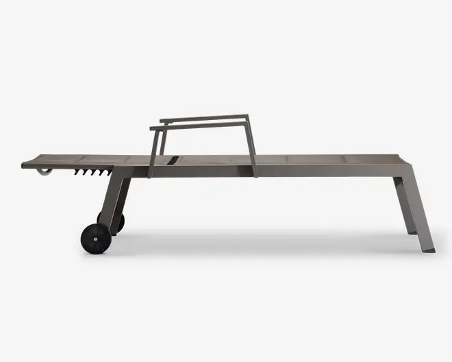 Elegant, moderne udendørs liggestol med justerbar ryglæn og et minimalistisk design. Stellet er lavet af metal med en mat finish og har to store hjul i den ene ende for nem mobilitet. Benene er skråtstillede for stabilitet, og sædet er fladt og langt, velegnet til afslapning. Det samlede udtryk er moderne og funktionelt, ideelt til brug ved poolen eller på terrassen.