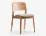 Stol med let træramme og let buet ryglæn for ergonomisk støtte. Sædet er polstret med en lys beige pude, der giver ekstra komfort. Benene er lige og robuste med en naturlig træfinish, der fremhæver træets årer. Designet er minimalistisk og moderne, velegnet til spisebord eller kontor.