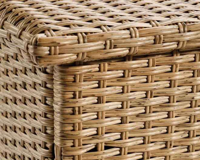 Nærbillede af en tæt flettet rattanstruktur i en naturlig lysebrun farve. Fletmønstret er ensartet og robust med vandrette og lodrette strimler, der er flettet sammen for at skabe en holdbar og æstetisk overflade. Kanterne er pænt afsluttede og viser omhyggeligt håndværk samt et glat, afrundet hjørne.
