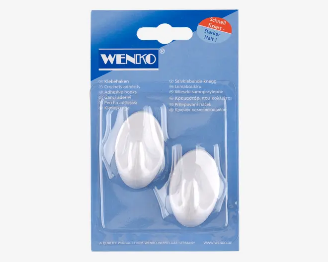 To ovale, hvide plastikkroge med blank overflade, pakket i en gennemsigtig blisterpakning på en blå papbaggrund. Krogene er selvklæbende og beregnet til nem montering på væg uden brug af værktøj. Emballagen viser mærket 'Wenko' og fremhæver egenskaber som stærkt greb og hurtig fastgørelse.