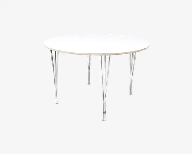 Rundt bord med en glat, hvid bordplade og seks slanke ben i sølvfarvet metal. Benene har et let industrielt udseende med synlige støttebøjler og bolte, hvilket giver stabilitet og et moderne udtryk. Bordet har et minimalistisk design, der passer til moderne indretning.