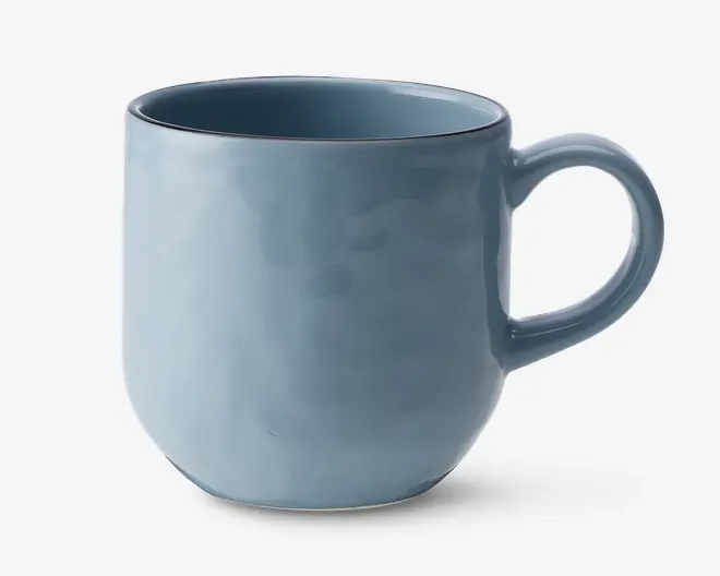 Et keramikkrus med en glat, blank lyseblå overflade. Kruset har en rundet krop, let tilspidset bund og et stort, behageligt håndtag. Krusets kant er diskret markeret med en tynd, mørkere blå linje, som giver et elegant kontrast. Indersiden er glaseret i samme blå farve som ydersiden.