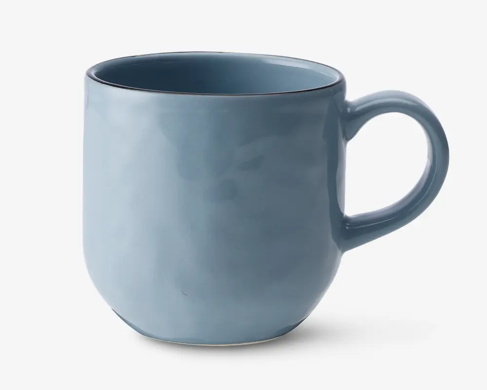 Et keramikkrus med en glat, blank lyseblå overflade. Kruset har en rundet krop, let tilspidset bund og et stort, behageligt håndtag. Krusets kant er diskret markeret med en tynd, mørkere blå linje, som giver et elegant kontrast. Indersiden er glaseret i samme blå farve som ydersiden.