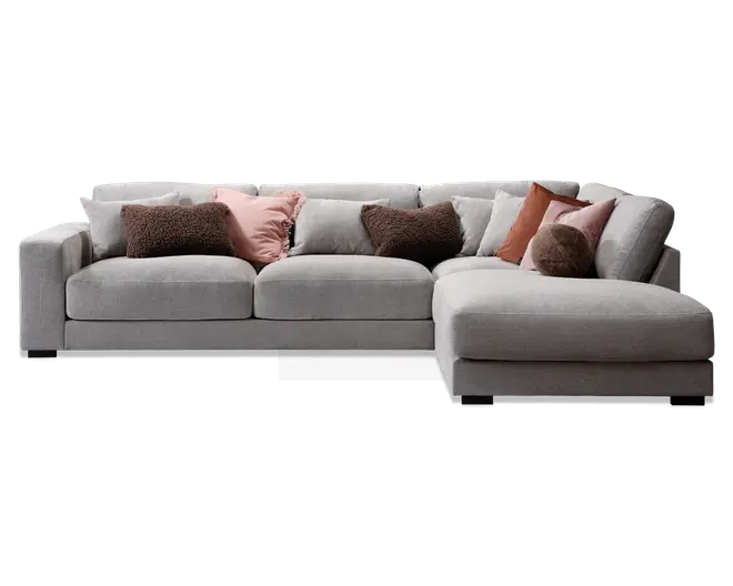 Moderne hjørnesofa med chaiselong til højre, betrukket med lysegråt stof. Sofaen har brede, firkantede armlæn og dybe, bløde sædehynder for ekstra komfort. Leveres med flere pyntepuder i forskellige teksturer og farver, herunder brun, rosa og rust, som giver et hyggeligt og stilfuldt udtryk.