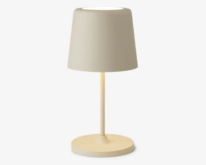 En lille, moderne bordlampe med en cylindrisk beige fod og en matchende beige lampeskærm. Lampen har et enkelt, minimalistisk design med rene linjer og en glat overflade, velegnet til moderne indretning.