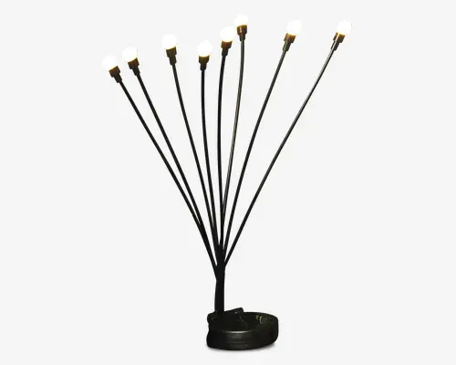 Moderne lampe med otte slanke, sorte metalarme, der strækker sig ud fra en rund fod, hver arm afsluttet med en lille, glødende kugleformet pære. Armene er arrangeret i et vifteformet mønster, hvilket giver et skulpturelt og moderne udtryk. Basen er solid og minimalistisk, hvilket understreger det elegante design.