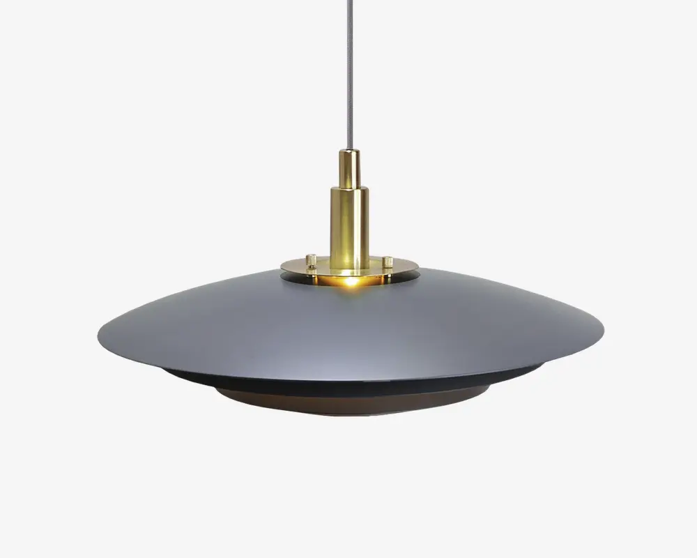 Loftlampe med en bred, flad, mat sort skærm med glat overflade. Den centrale del er lavet af poleret messing, hvilket giver et elegant og kontrastfuldt udtryk. Lampen hænger i en tynd, lige ledning, og det samlede design er moderne og minimalistisk, velegnet til nutidige indretninger.