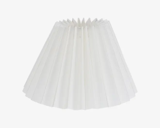 Hvid plisseret lampeskærm med konisk form og jævnt fordelte lodrette folder, der giver et tekstureret udseende. Stoffet er semi-transparent og giver en blød lysspredning. Topåbningen er mindre end bunden, og kanterne er pænt afsluttede.