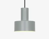 En moderne pendellampe med en matgrå cylindrisk metalskærm. Designet har en todelt struktur med en smallere cylinder øverst og en bredere cylinder nederst, hvilket giver et rent og geometrisk udtryk. Lampen hænger i en sort ledning, og indersiden af skærmen er hvid for at forbedre lysrefleksionen. Lampen giver nedadrettet lys, hvilket er ideelt til fokuseret belysning.