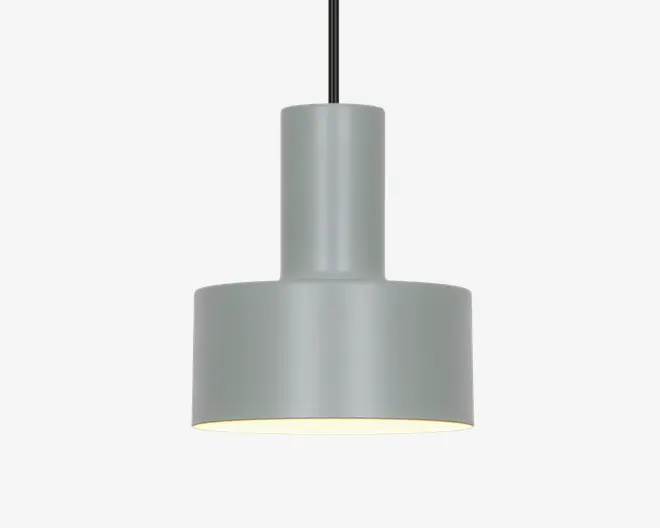En moderne pendellampe med en matgrå cylindrisk metalskærm. Designet har en todelt struktur med en smallere cylinder øverst og en bredere cylinder nederst, hvilket giver et rent og geometrisk udtryk. Lampen hænger i en sort ledning, og indersiden af skærmen er hvid for at forbedre lysrefleksionen. Lampen giver nedadrettet lys, hvilket er ideelt til fokuseret belysning.