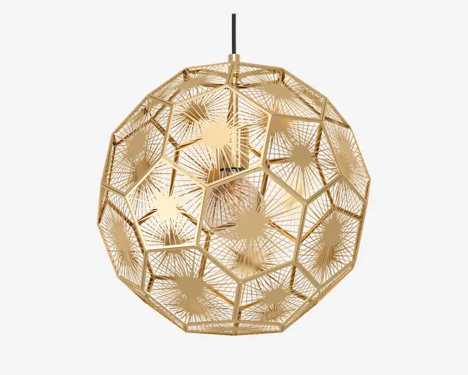 En kugleformet loftslampe lavet af guldfarvet metal. Skærmen består af sammenkoblede fem- og sekskantede paneler, der hver især har indviklede, laserskårne geometriske mønstre, som stråler ud fra et centralt punkt og skaber en stjerneeffekt. Det åbne design lader lyset skinne igennem og kaster dekorative skygger. Lampen hænger i en enkelt sort ledning.