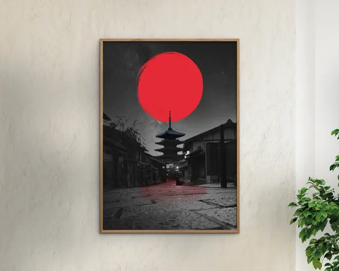 Indrammet vægkunst med et sort-hvidt fotografi af en traditionel japansk pagode og gade, hvor en stor, kraftig rød cirkel er malet over himlen over pagoden. Billedet har en dramatisk kontrast mellem den monokrome baggrund og den levende røde detalje, hvilket skaber en iøjnefaldende visuel effekt. Rammen er enkel og i træ, hvilket understreger kunstværkets minimalistiske stil.