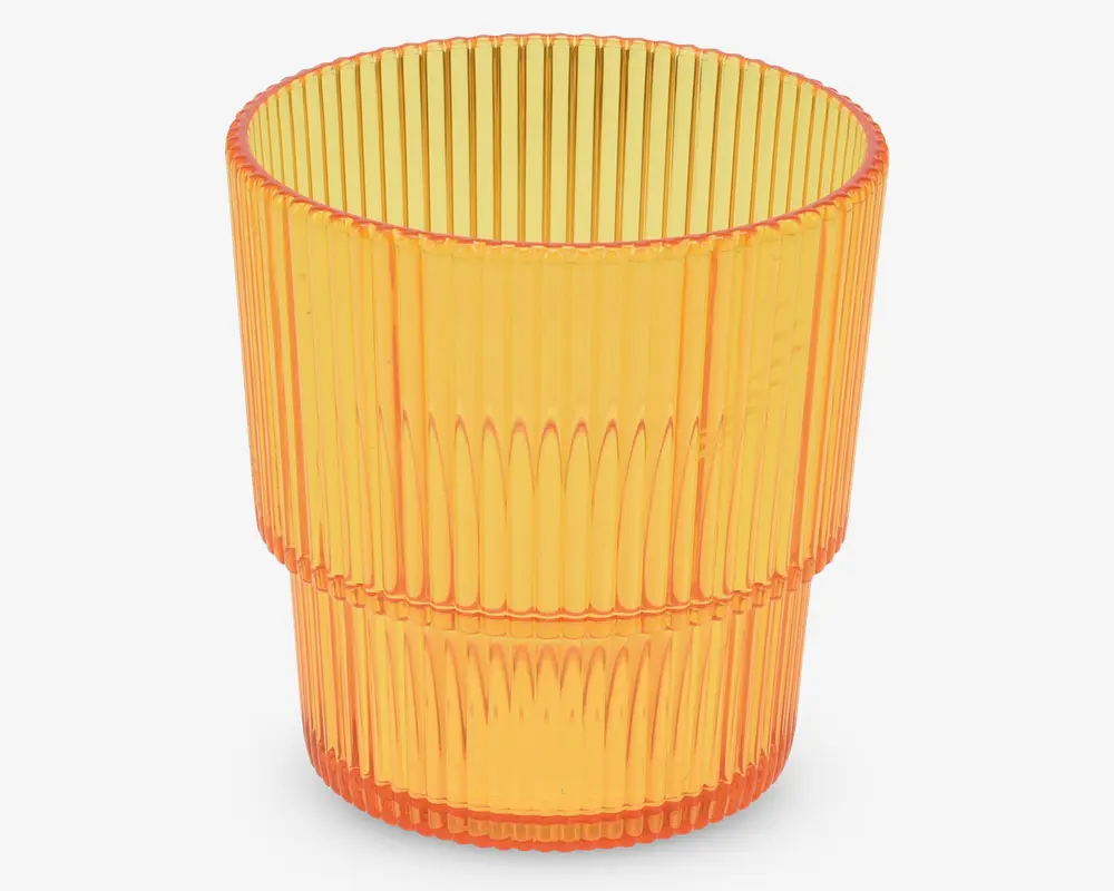 Et gennemsigtigt orange drikkeglas med lodret rillet tekstur og let udadgående kant. Glasset har et markant vandret bånd omkring midten, som deler det rillede mønster i to sektioner. Designet giver et moderne og stilfuldt udtryk.