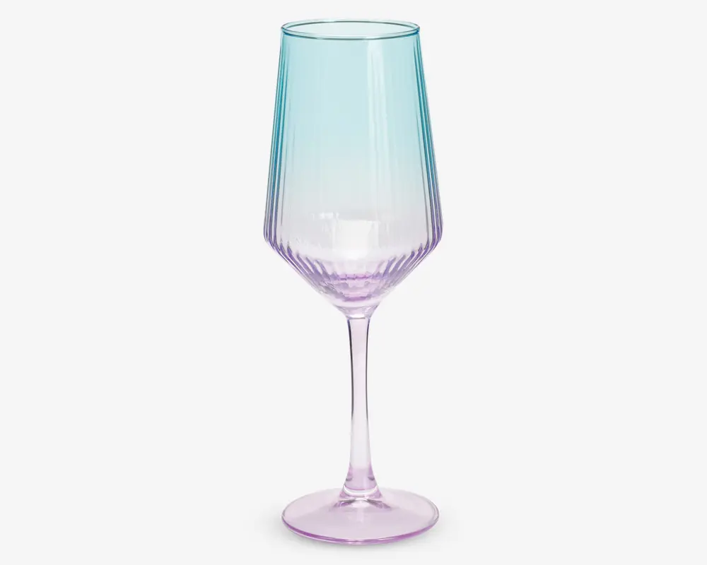 Høj, elegant glas med lang stilk og fløjteformet skål. Glasset har et farveforløb, der går fra lyseblå øverst til blid lilla ved bunden. Skålen har diskrete lodrette riller, som giver ekstra struktur og visuel effekt.