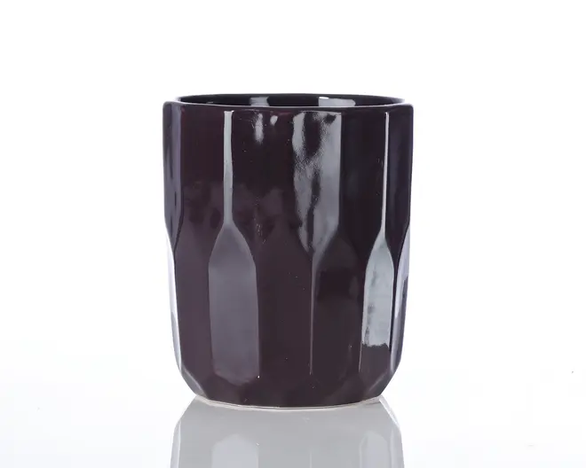 En mørklilla keramikkop med blank overflade og et facetteret, geometrisk design. Koppen har lige sider og en let afrundet kant, hvilket giver den et moderne og stilfuldt udtryk.