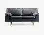 En moderne to-personers sofa betrukket med glat sort læder og udstyret med bløde, aftagelige ryg- og sædehynder. Sofaen har brede, polstrede armlæn og står på fire lyse træben, hvilket giver et nutidigt udtryk. Designet er minimalistisk, og materialerne tyder på nem vedligeholdelse og god komfort.