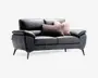 En moderne 2-personers sofa betrukket med glat sort læder og bløde, polstrede armlæn og sædehynder. Sofaen har slanke, skrå metalben, der giver et moderne udtryk. Den er pyntet med tre dekorative puder: én i et tekstureret, fluffy brunt stof og to i et blødt, lysebeige materiale, hvilket tilføjer både komfort og stil.