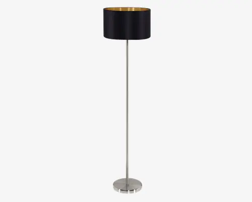 Høj gulvlampe med en slank, cylindrisk fod i børstet sølvmetal. Lampen har en rund, sort lampeskærm med en guldfarvet inderside, som giver et elegant udtryk og et varmt lys. Designet er moderne og minimalistisk, velegnet til nutidige indretninger.
