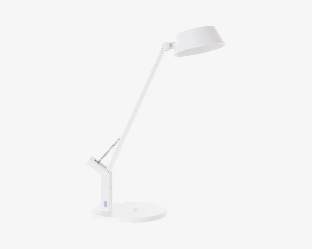 En moderne, minimalistisk hvid skrivebordslampe med rund fod og justerbar arm. Lampens hoved er cirkulært og kan vippes for retningsbestemt belysning. Armen har to led, der giver fleksibel placering, og det samlede design er slankt og stilrent, velegnet til moderne arbejdsområder.