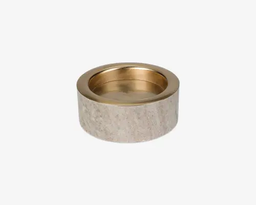 Rund skål med en tyk, cylindrisk base af lysegråt stenmateriale og en aftagelig, gylden metalindsats. Stenoverfladen er glat og mat, mens den indvendige skål er blank og reflekterende. Designet er moderne og elegant, velegnet til servering eller som dekoration.