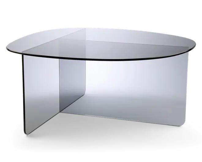 Moderne sofabord med et klart glasdesign og en unik geometrisk form. Bordpladen er rundet med glatte kanter, og basen består af to krydsende glasplader, som giver stabilitet og et visuelt markant udtryk. Det gennemsigtige materiale giver bordet et minimalistisk og elegant look, der passer til moderne indretning.