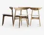 Sæt med fire stole i minimalistisk, skandinavisk-inspireret design. Hver stol har et buet ryglæn i træ, skrå ben og en let polstret, hvid sædehynde. Træet har en naturlig finish, der fremhæver årer og struktur. Udtrykket er stilrent og moderne, velegnet til spise- eller kontormiljøer.