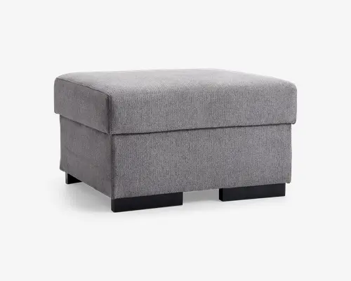 Firkantet puf med en blød, polstret top og betrukket med lysegråt stof. Puffen har rene, moderne linjer og står på korte, solide sorte ben. Stoffet har en diskret vævet struktur, og det samlede design er minimalistisk, hvilket gør den velegnet til moderne indretninger.