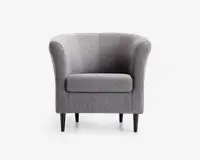 En moderne lænestol med rund ryglæn og let udadbuede armlæn, polstret med lysegråt stof. Sædepuden er tyk og blød for ekstra komfort. Stolen står på fire slanke, koniske sorte ben, hvilket giver et stilrent og elegant udtryk.