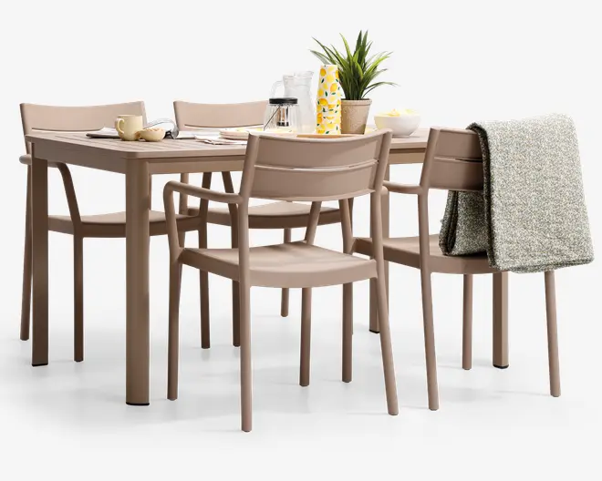 Sættet består af et rektangulært bord og seks matchende stole, alle i en mat taupe-farve. Stolene har let buede ryglæn og enkle, lige ben for et moderne udtryk. Bordet er dækket op til morgenmad med kopper, tallerkener, en karaffel, en potteplante og et sammenrullet gråt tæppe lagt over ryggen på en af stolene. Designet er minimalistisk og funktionelt, velegnet til moderne spisestuer.