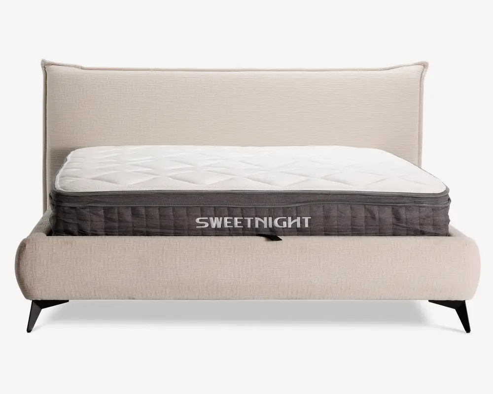 En tyk madras med quiltet hvid top og mørkegrå sidepanel, hvor mærket 'SWEETNIGHT' står med store hvide bogstaver. Madrassen har en blød, polstret overflade med diamantmønstret syning på toppen og solide sidehåndtag til nem løftning. Den er placeret på en moderne, polstret sengestel med lysebeige stof og høj, polstret sengegavl.