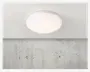 En rund, loftmonteret lampe med en glat, hvid, matteret skærm, der fordeler lyset jævnt. Lampen har et minimalistisk design med lav profil, hvilket gør den velegnet til moderne indretning. Lampen ser ud til at være lavet af plast eller glas og er monteret på et ensfarvet, hvidt loft.