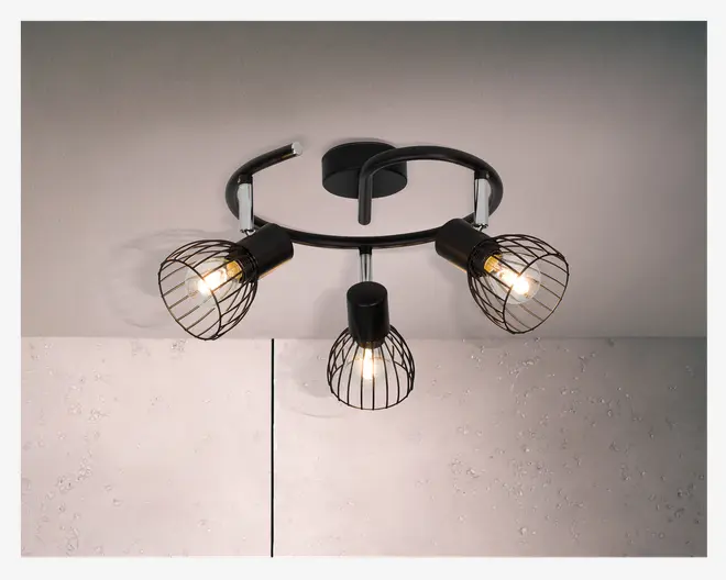 Loftmonteret lampe med tre justerbare lampehoveder, hver med en sort metalskærm i burdesign. Lampen har et moderne, industrielt udtryk med en buet sort metalbase og synlige pærer, hvilket giver en stilfuld og funktionel belysningsløsning.
