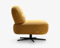 Sideview af en moderne loungestol med tyk, polstret sæde og ryglæn betrukket med sennepsgul tekstureret stof. Stolen har en lav, bred profil med afrundede kanter og står på en sort metal drejefod med fire ben. Et lille mærke med brandnavn ses på den nederste side af sædet.