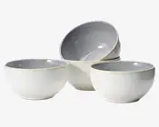Sæt med fire keramiske skåle med en glat, rund form. Ydersiden er mat og offwhite, mens indersiden har en blank, lysegrå finish. Skålene har et minimalistisk design med let tilspidset kant, hvilket gør dem velegnede til servering af suppe, salat eller morgenmad. Den diskrete farvekontrast mellem inderside og yderside giver et moderne udtryk.